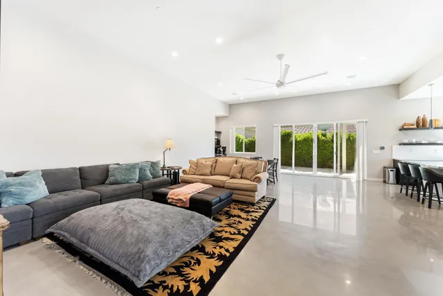 a kitchen with stainless steel appliances kitchen island granite countertop a table chairs sink and cabinets