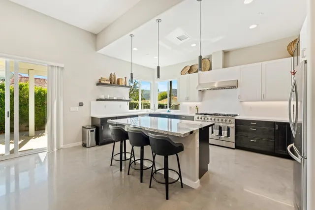 a kitchen with stainless steel appliances granite countertop a stove a refrigerator and a refrigerator