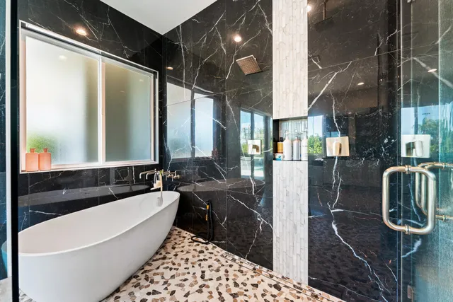 a spacious bedroom with a bed a couch and a flat tv screen