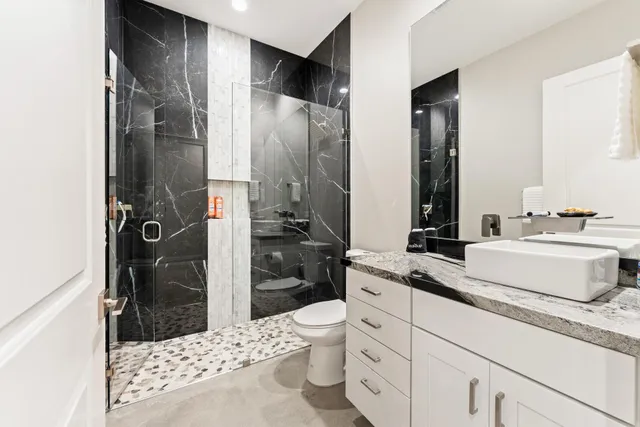 a bathroom with a sink a toilet and shower