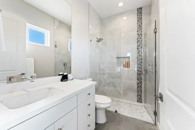 a bathroom with a sink a toilet and shower