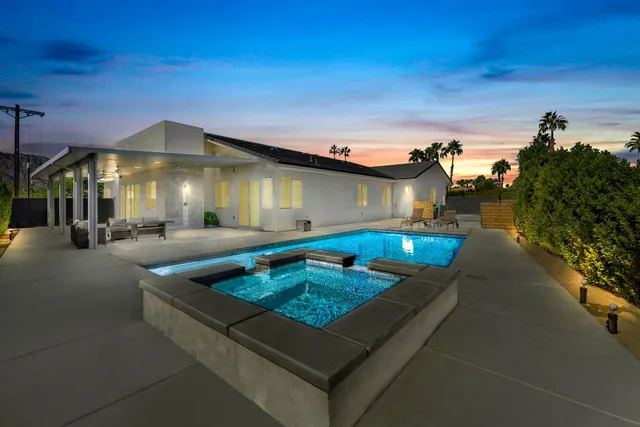 a view of a house with swimming pool and sitting area