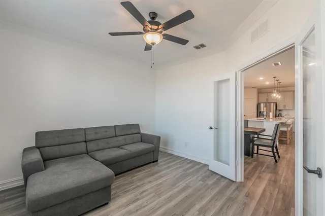 a living room with furniture and a wooden floor
