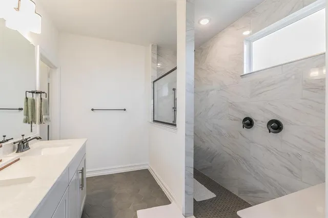 a bathroom with a granite countertop sink a shower and mirror