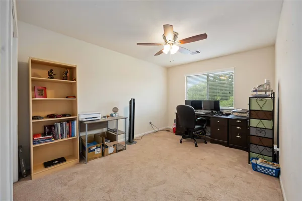 a view of a workspace with furniture and a window