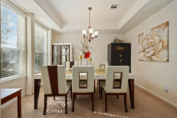 a dining room with furniture a chandelier and a window