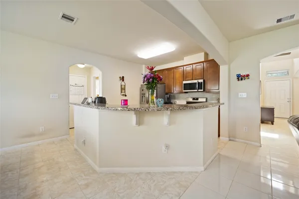 a view of kitchen with stainless steel appliances granite countertop a refrigerator and a sink
