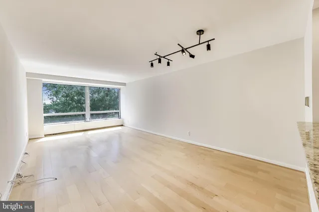 a view of a room with a white wall and a window