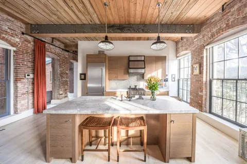 a kitchen with stainless steel appliances granite countertop a sink a stove cabinets and wooden floor