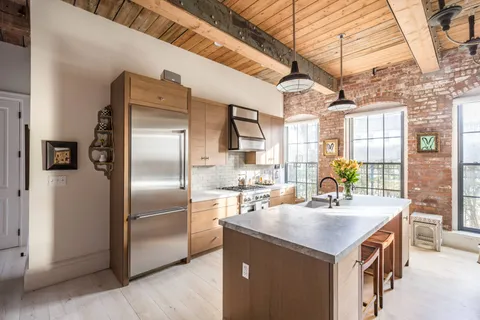 a kitchen with kitchen island a counter top a sink appliances and cabinets