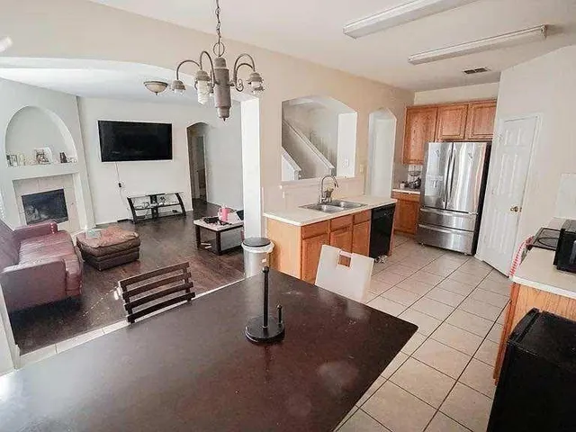 a living room with furniture a flat screen tv and a chandelier