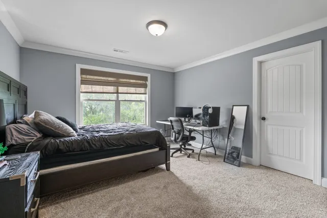 a view of a hallway with wooden floor and a bathroom