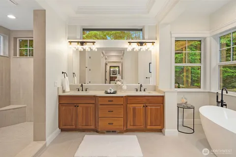 a bathroom with a granite countertop sink mirror and a bathtub