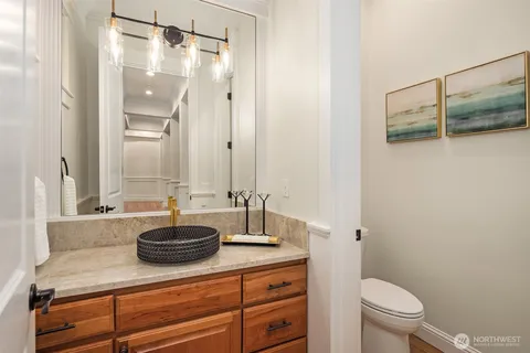 a bathroom with a granite countertop sink a toilet and a mirror