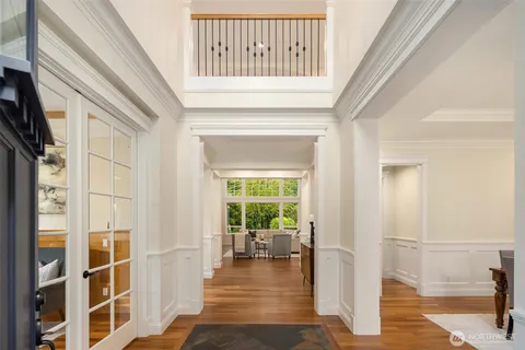 a view of a hallway with wooden floor and a living room