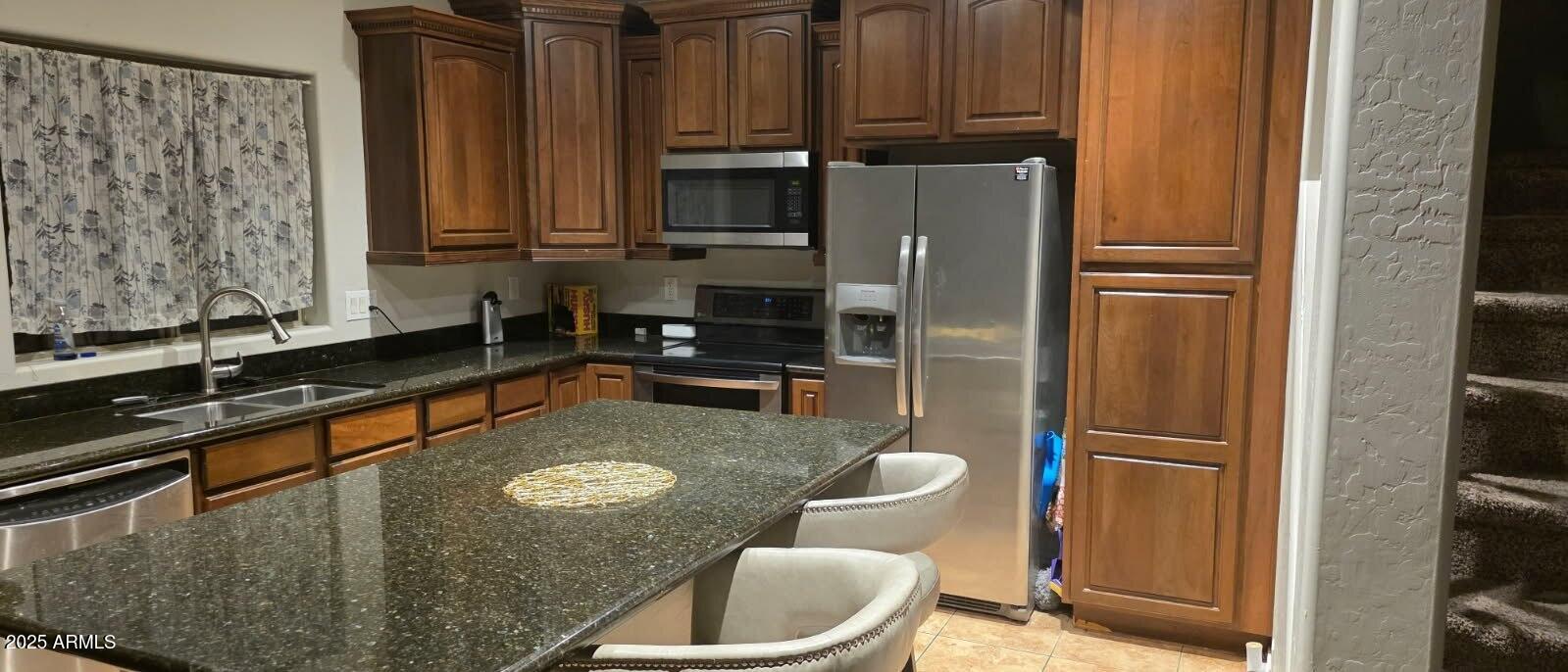 4717 East Redfield Road Gilbert, AZ 85234 - Photo 3 of 13 a kitchen with stainless steel appliances granite countertop a refrigerator a sink a stove and a microwave oven