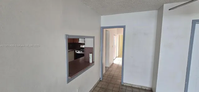 a view of a hallway and a livingroom with furniture