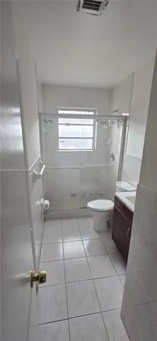 a bathroom with a sink a toilet and a window