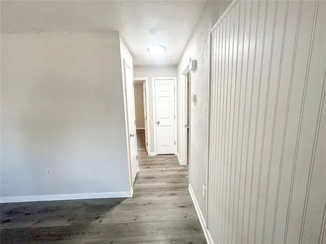 a view of a hallway with wooden floor