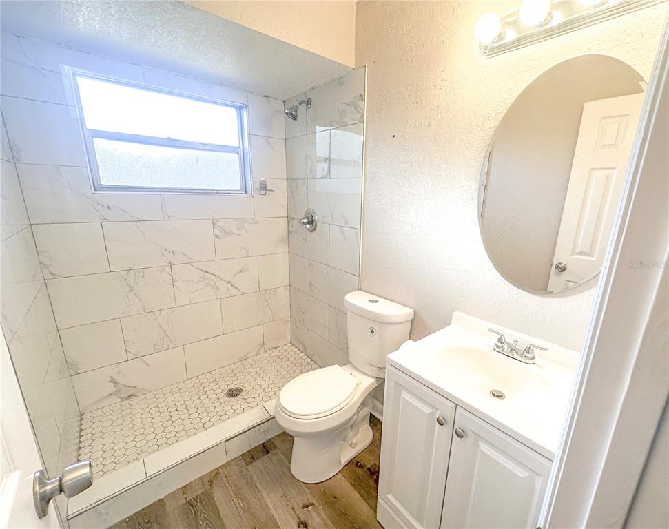 4135 Old Road 37 Lakeland, FL 33813 - Photo 10 of 11 a white toilet sitting next to a bathroom sink and a mirror