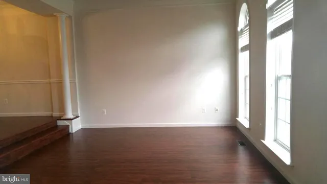a view of an empty room with wooden floor