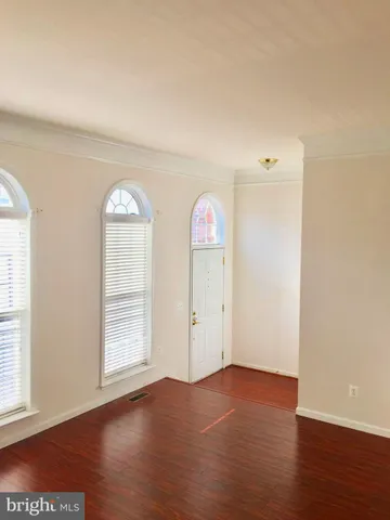a view of a room with wooden floor and windows