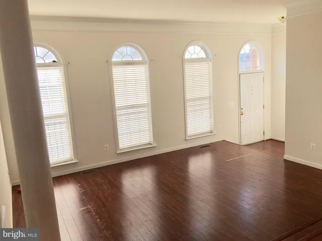 a view of a room with wooden floor and windows
