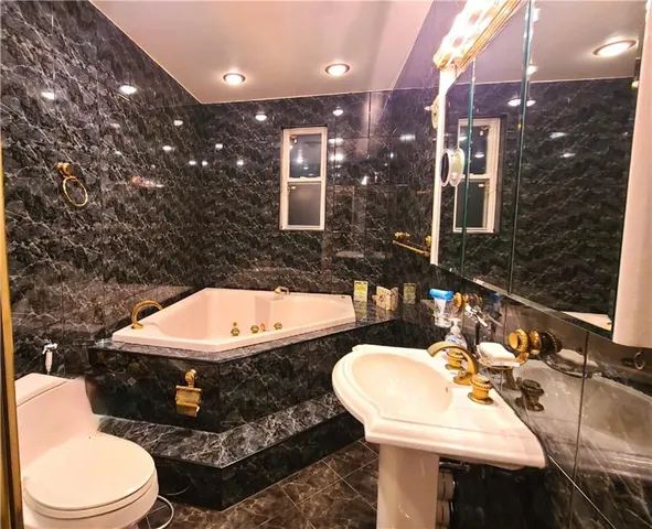 a bathroom with a tub sink and mirror