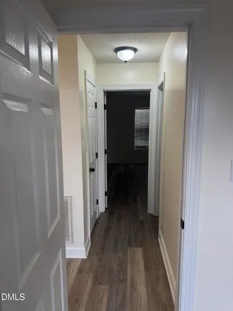 a view of a hallway with wooden floor