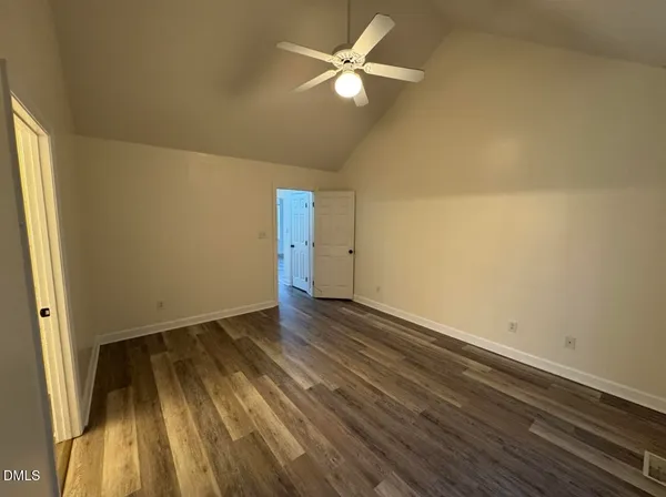 an empty room with wooden floor and a ceiling fan