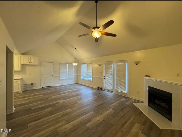 a view of a livingroom with a chandelier fan and a fireplace