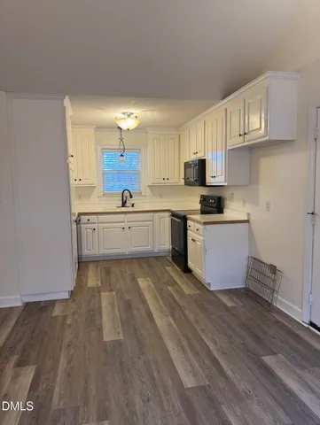 a large kitchen with cabinets and wooden floor