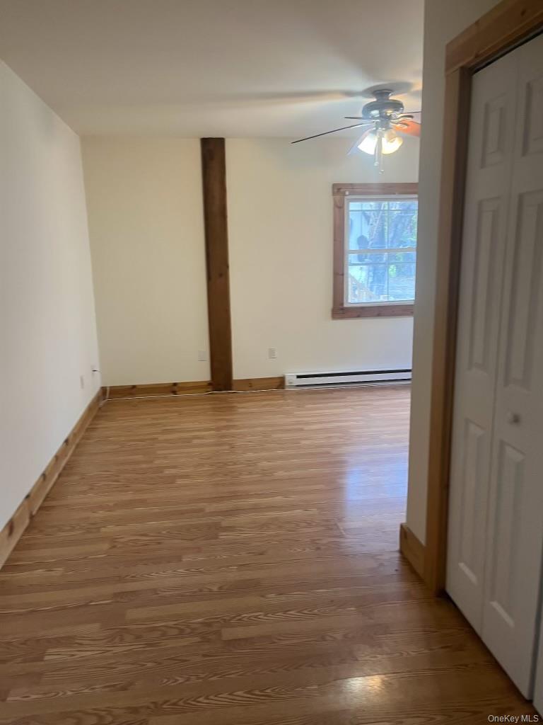 1027 Beekman Road, Unit 1A Hopewell Junction, NY 12533 - Photo 3 of 7 a view of an empty room with wooden floor and a window