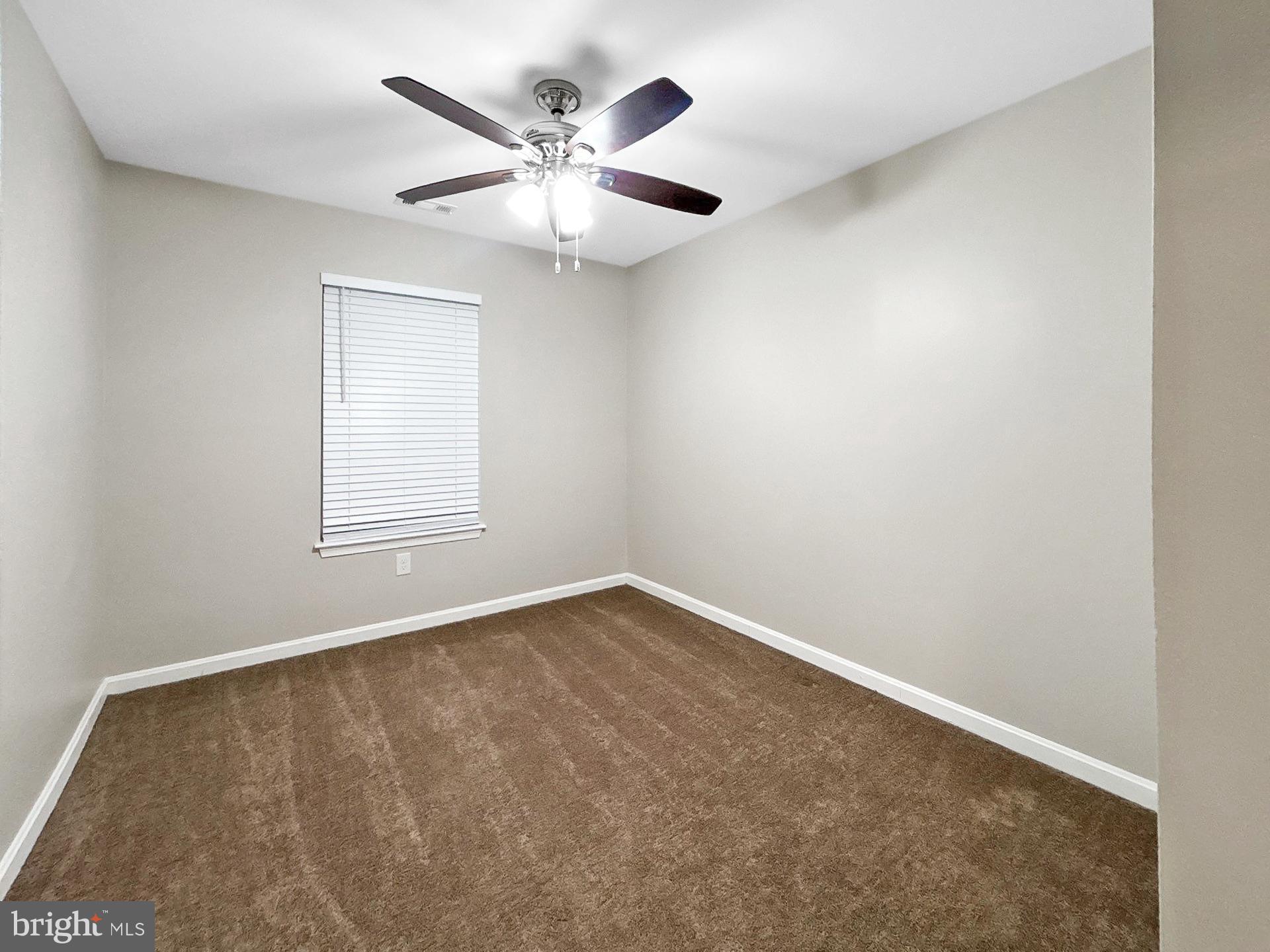 3558 Corn Stream Road Randallstown, MD 21133 - Photo 9 of 27 an empty room with a chandelier fan and windows