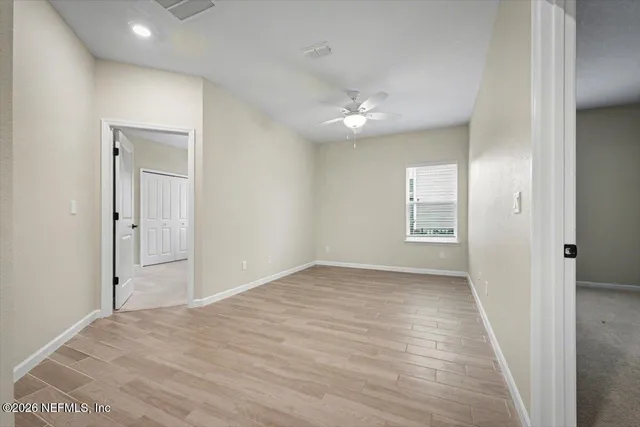 a view of empty room with wooden floor