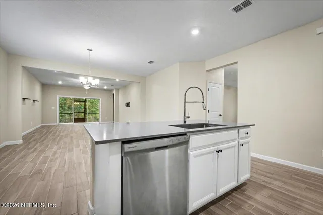 a view of a sink and window with wooden floor