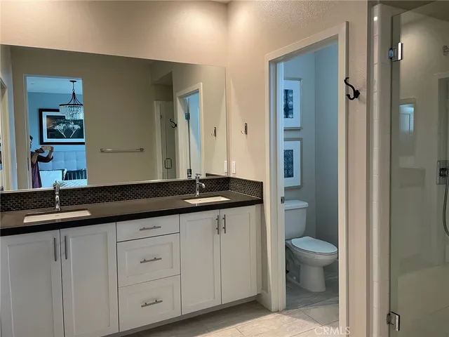 a bathroom with a granite countertop sink a toilet and a mirror