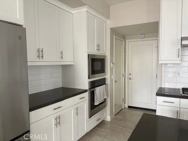 a kitchen with white cabinets and appliances