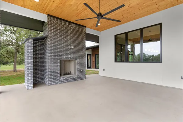 a view of an empty room with a fireplace and a window