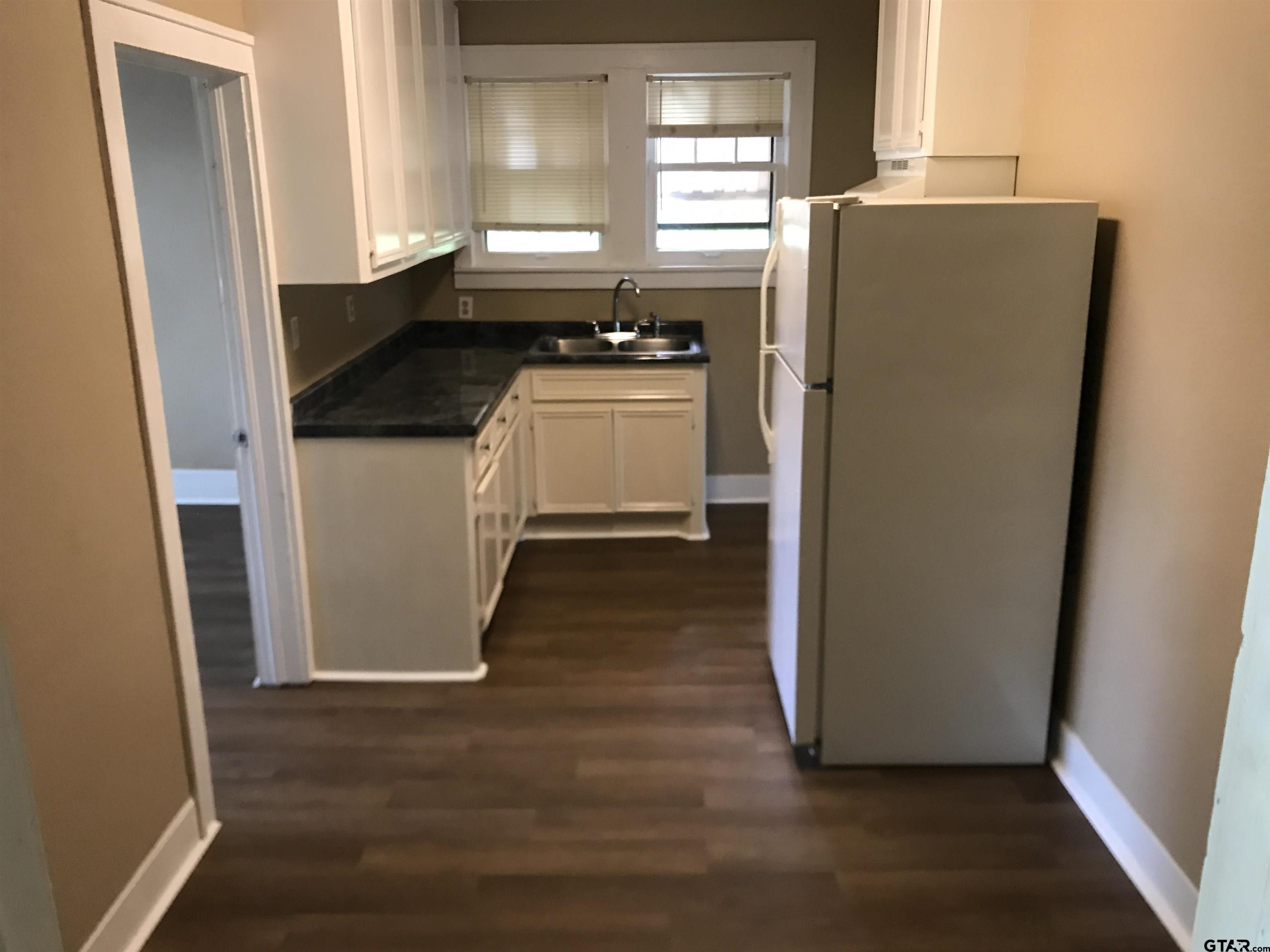 208 West Phillips Street, Unit 200 Tyler, TX 75701 - Photo 7 of 11 a kitchen with a refrigerator and window