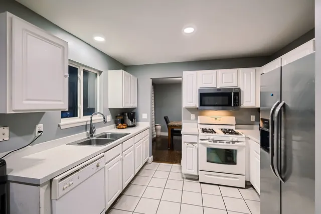 a kitchen with white cabinets stainless steel appliances and sink