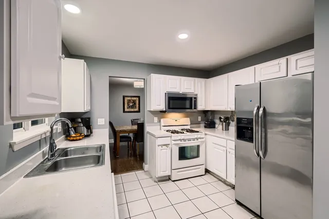 a kitchen with a refrigerator and a stove top oven