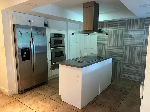 a kitchen with stainless steel appliances kitchen island a refrigerator and a stove