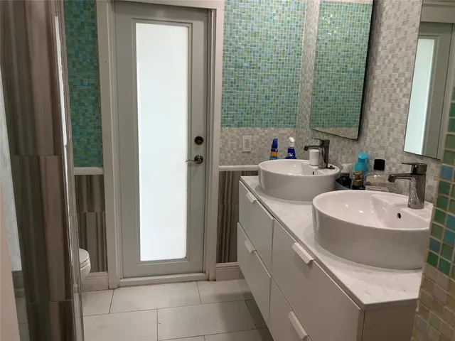 a bathroom with a double vanity sink a mirror and a bathtub