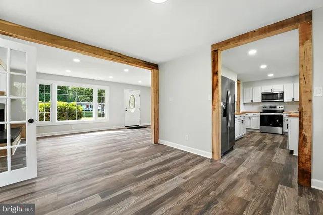 a view of a big room with wooden floor and windows
