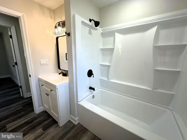 a bathroom with a tub a sink and a large mirror