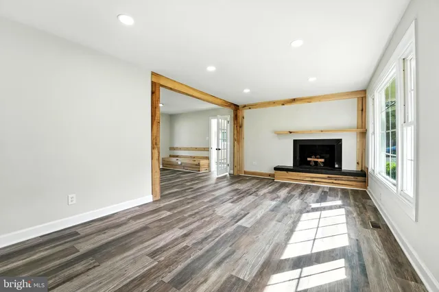 a view of empty room with wooden floor and fireplace