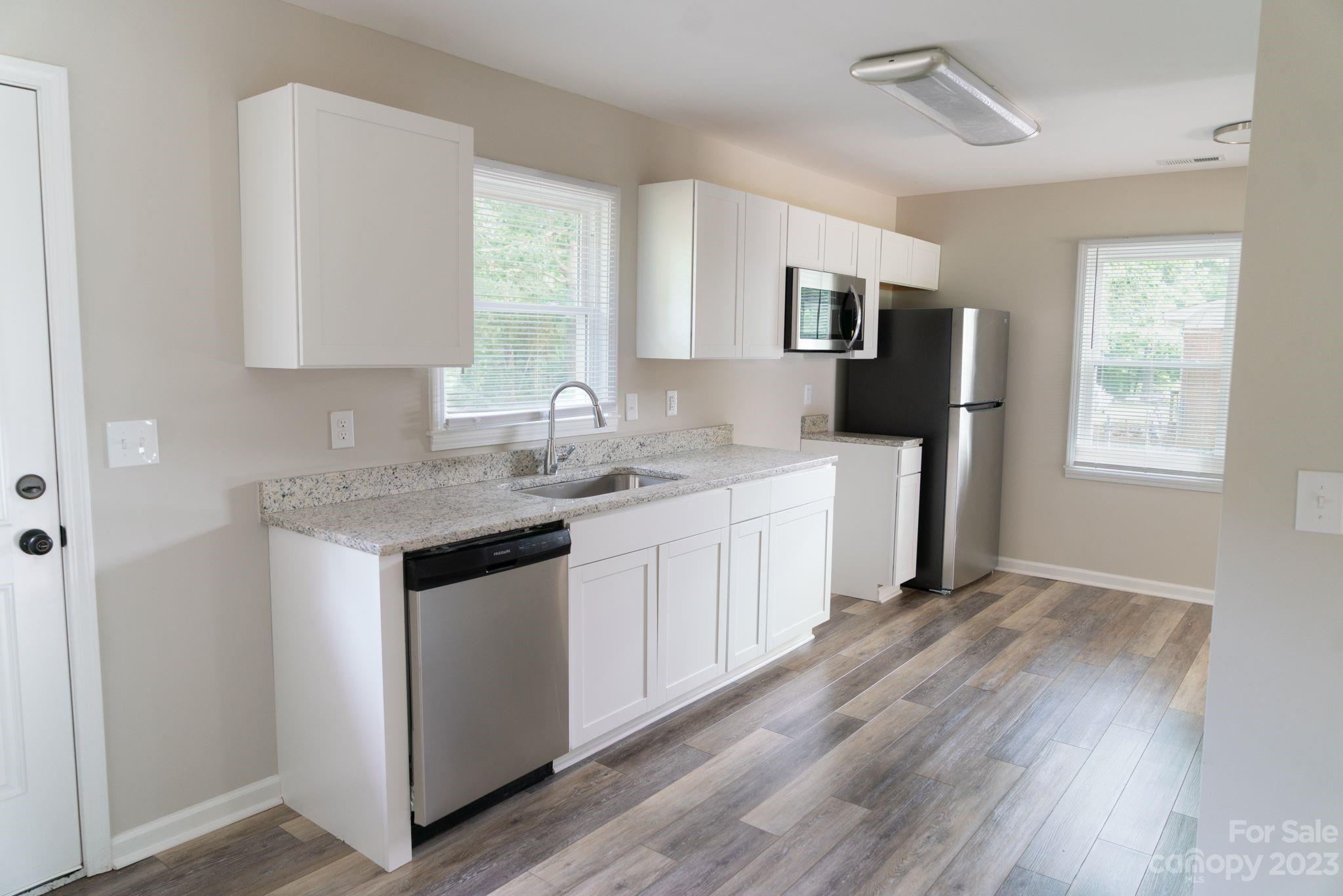 41276 Kings Road New London, NC 28127 - Photo 4 of 12 a kitchen with stainless steel appliances granite countertop a sink stove and refrigerator