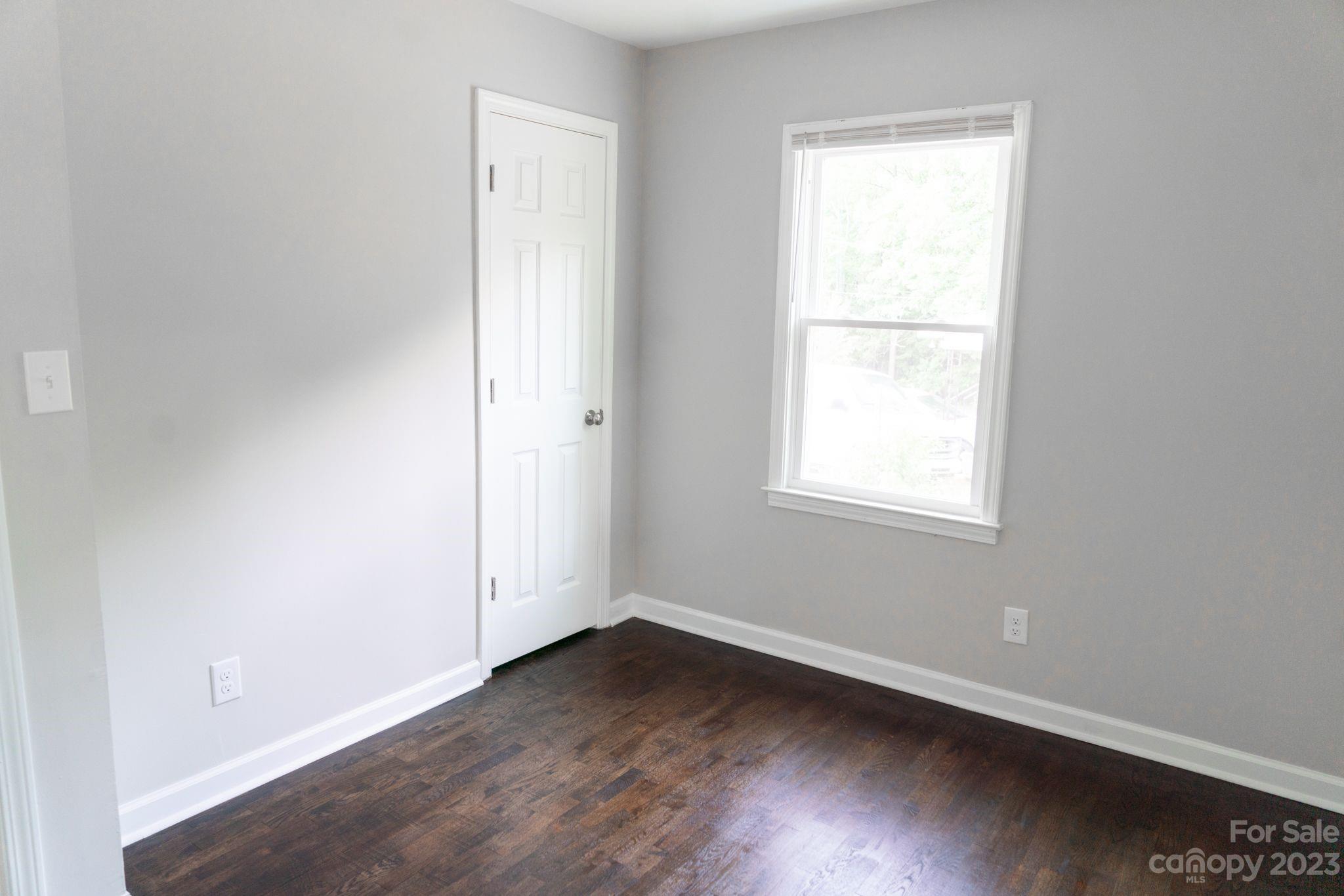 41276 Kings Road New London, NC 28127 - Photo 7 of 12 an empty room with wooden floor and windows