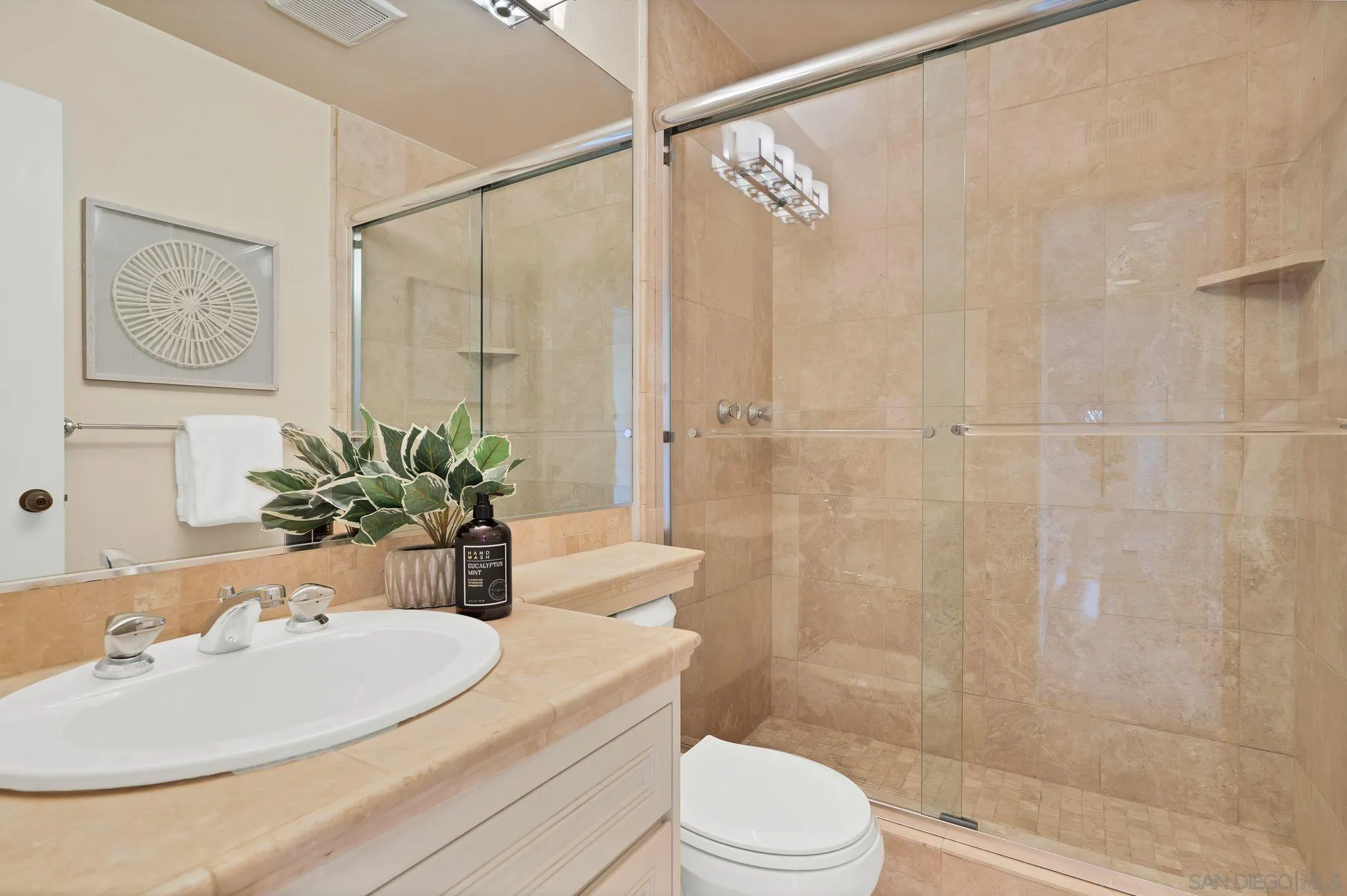 560 Torrey Point Road Del Mar, CA 92014 - Photo 24 of 35 a bathroom with a sink a toilet a glass door a shower and a mirror